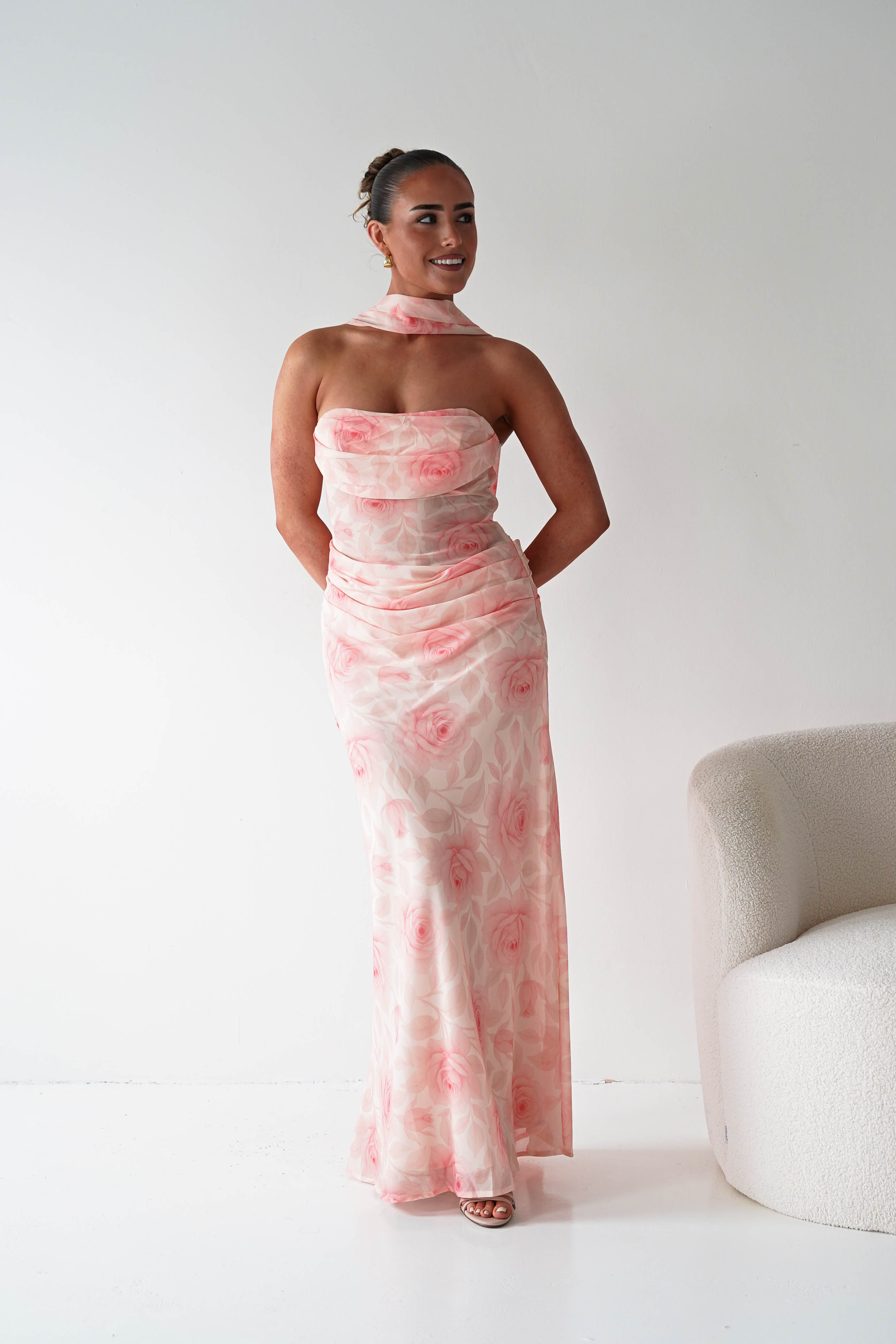 Woman wearing a pink floral dress against a white background