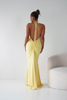 Woman wearing a yellow evening gown with a white background
