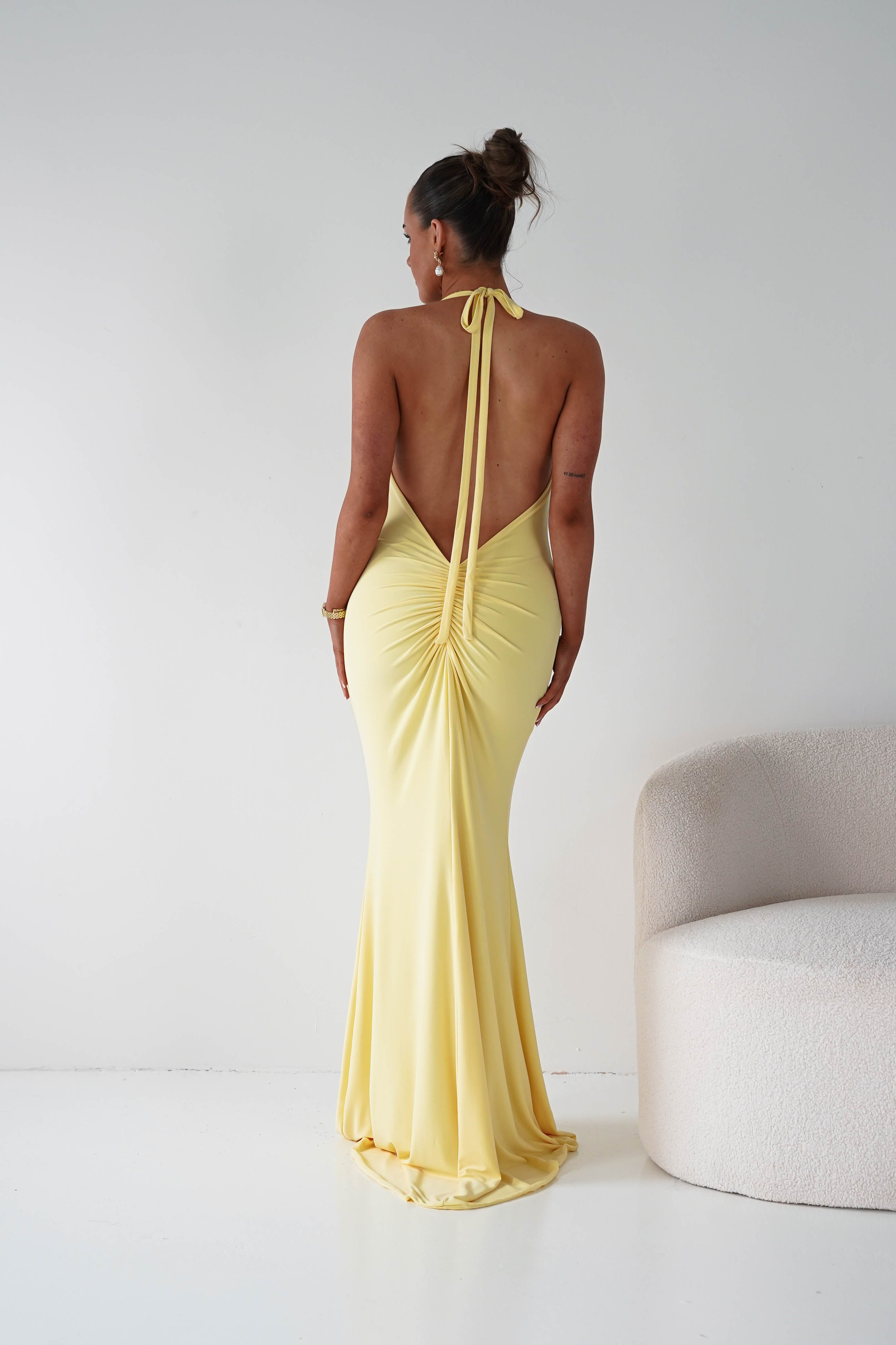 Woman wearing a yellow evening gown with a white background