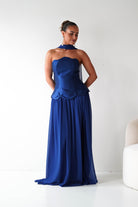 Woman wearing a blue strapless gown against a white background